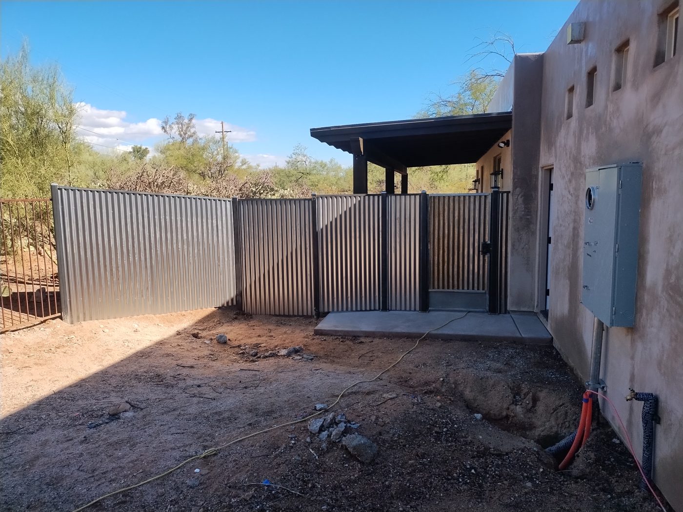 Corrugated fence with metal ramada — Emery Welding & Ironwork